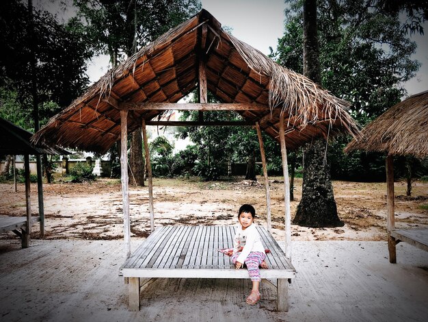 Full length of woman on bench against trees