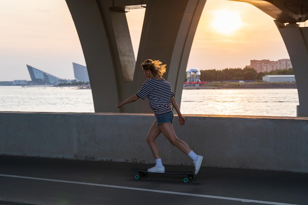 夕暮れの空に照らされた海の上の女性の全長