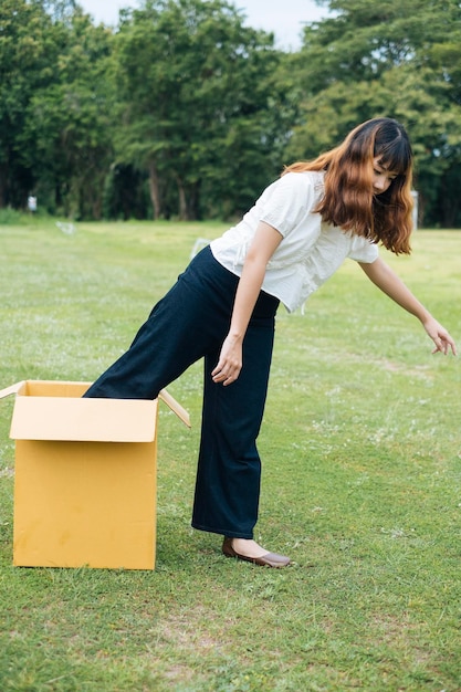 草の上で箱から出てくる女性の全長