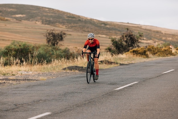 Full length of woman cycling on road