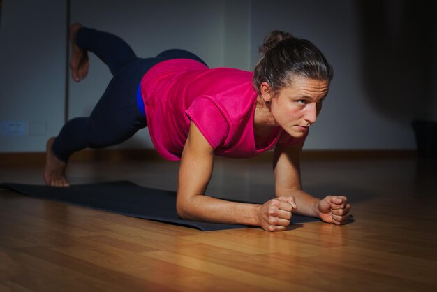 Photo full length of woman exercising on floor