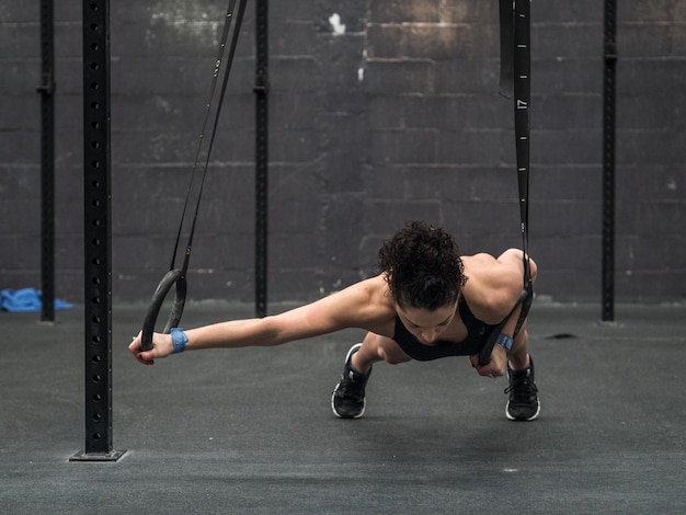 Photo full length of woman exercising at gym