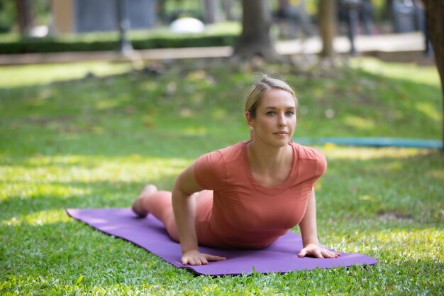 公園でマットの上を行使する女性の全長