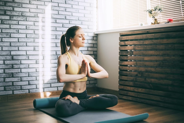 Full length of woman meditating at home
