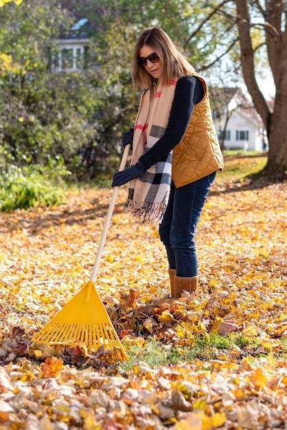 Photo full length of woman raking at yard