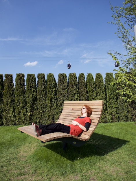 Foto lunghezza completa di una donna che si rilassa su una panchina al parco