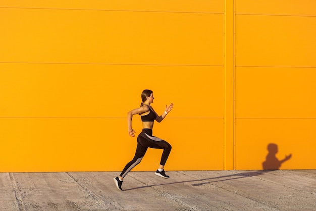 Full length of woman running on wall