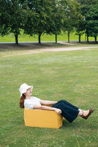 Photo full length of woman sitting on box in grass