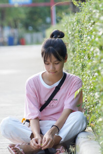 Photo full length of woman sitting by plants outdoors