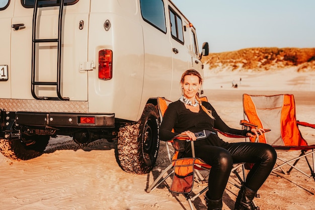 Photo full length of woman sitting by van on beach