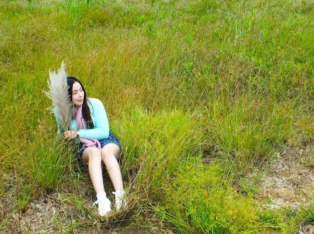 Full length of woman sitting on field