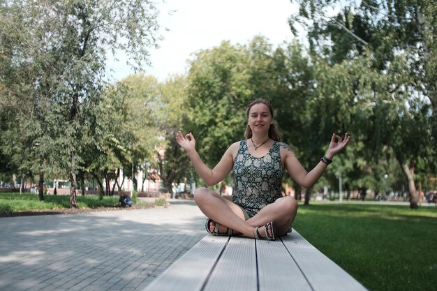 Foto lunghezza completa di una donna seduta nel parco