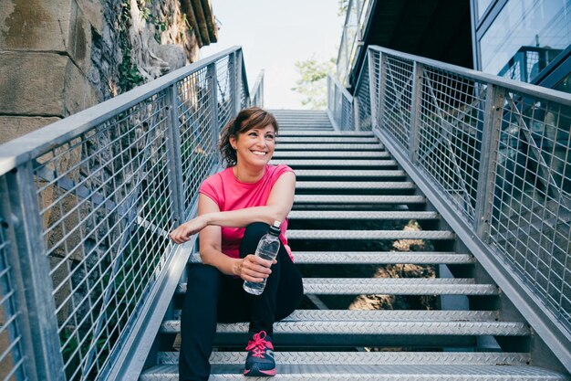 Full length of woman sitting on staircase