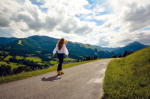 空に向かって道路でスケートボードをしている女性の全長