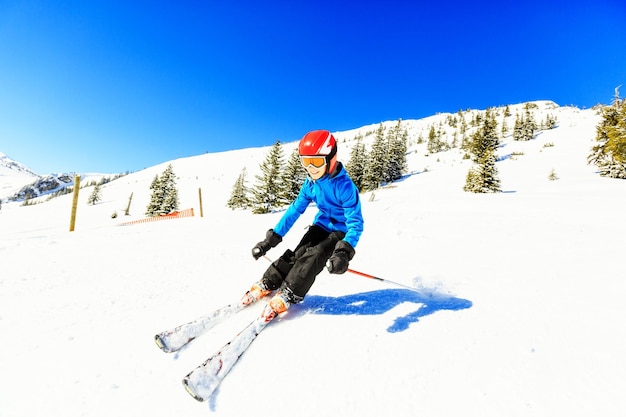 Foto lunghezza completa di una donna che scia su una montagna innevata contro un cielo limpido