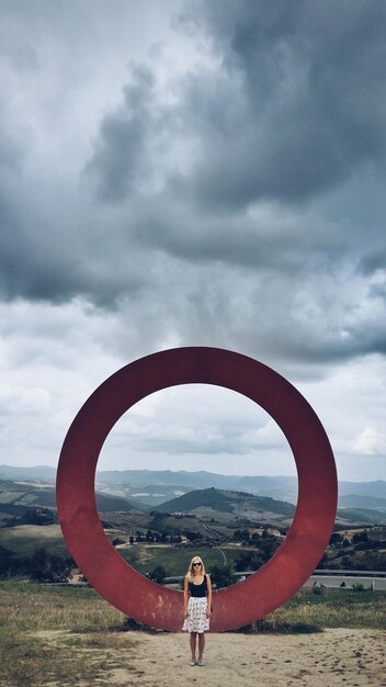 Foto lunghezza completa di una donna in piedi contro un grande cerchio
