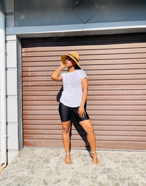 Photo full length of woman standing against wall in south african township