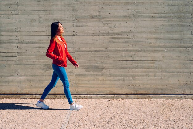 Foto lunghezza completa di una donna in piedi contro il muro