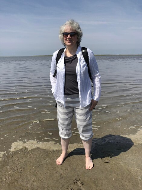 Photo full length of woman standing at beach against sky