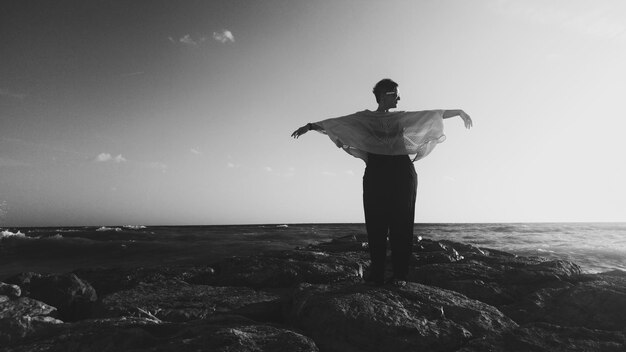 Full length of woman standing at beach against sky