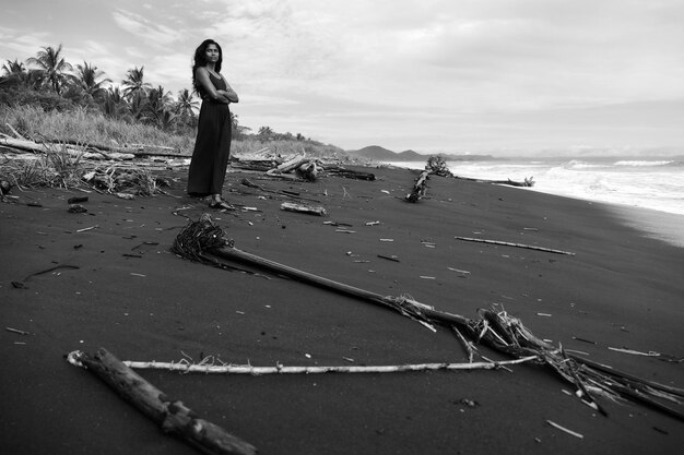 Full length of woman standing at beach against sky