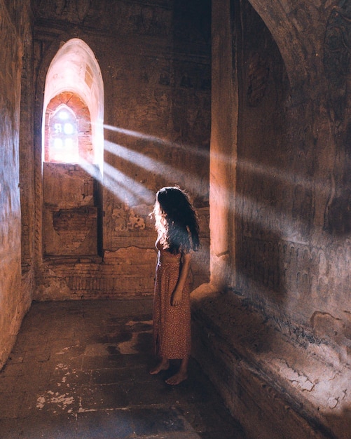 full length of woman standing by old wall
