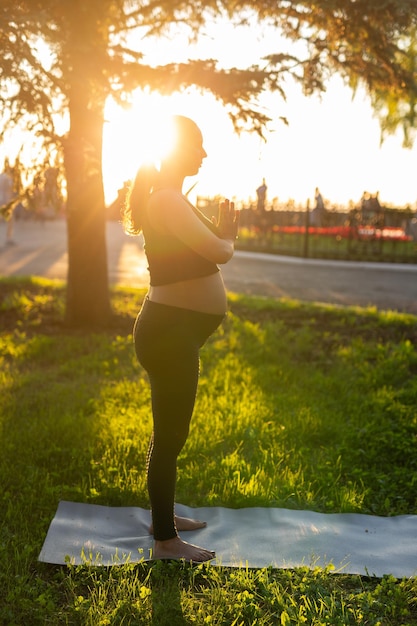 Foto lunghezza completa di una donna in piedi sul campo contro il sole brillante