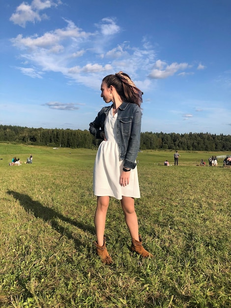 Full length of woman standing on field against sky