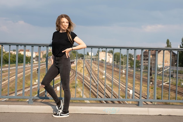 Foto lunghezza completa di una donna in piedi su un ponte pedonale contro il cielo