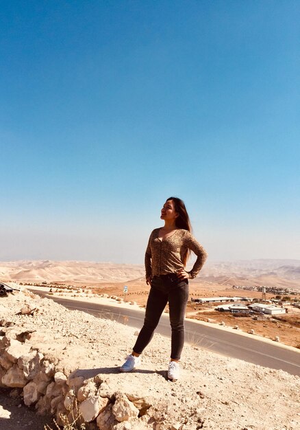 Full length of woman standing on land against clear sky