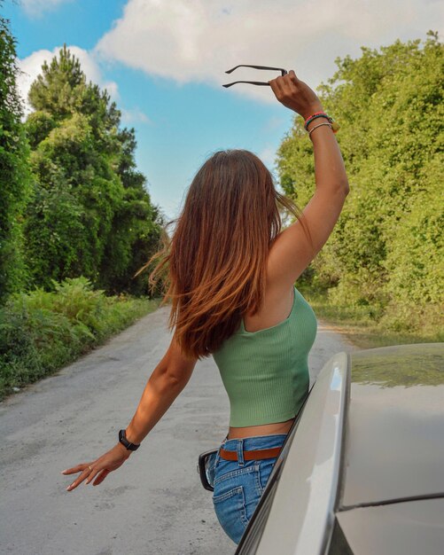 Photo full length of woman standing on road against trees