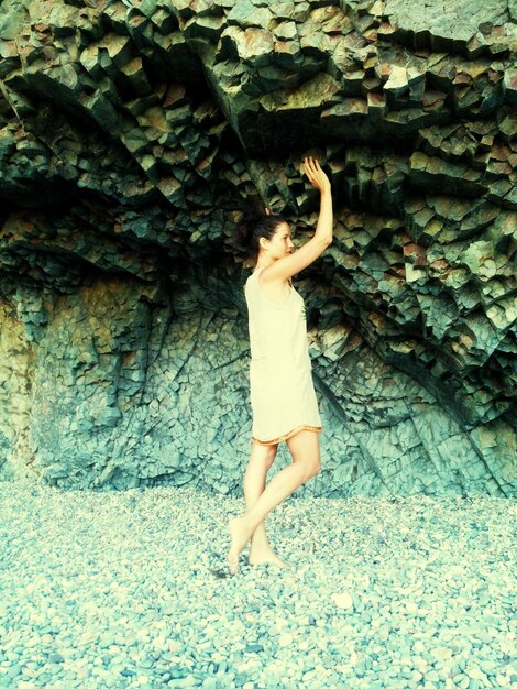 Photo full length of woman standing below rock formation at beach