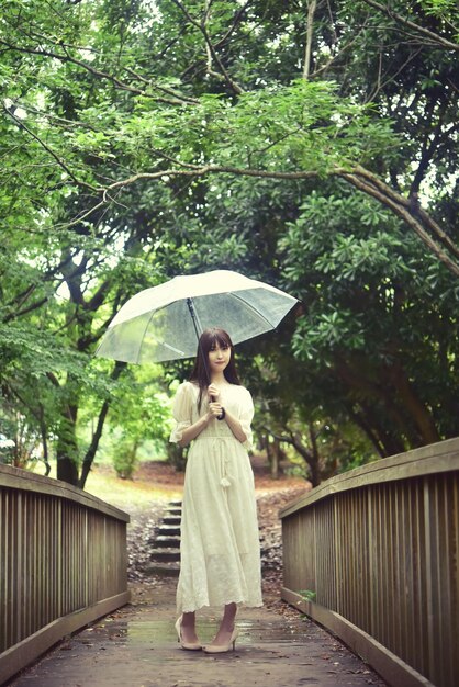 Full length of woman standing on wet footpath