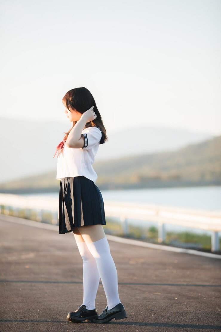 Photo 유니폼을 입은 전체 길이의 여성이 야외에 서 있습니다.