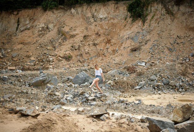 Foto lunghezza completa di una donna che cammina sulle rocce