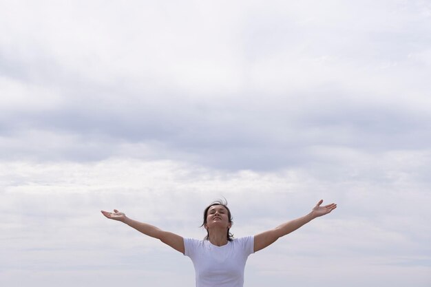 Photo full length of woman with arms raised against sky