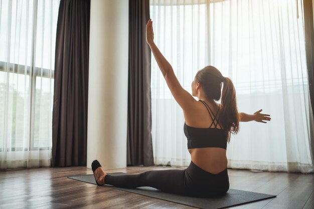 Photo full length of woman with arms raised while standing against window