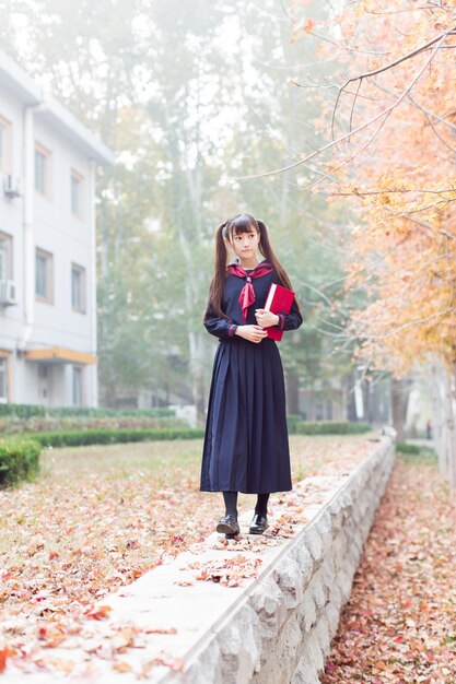 Full length of woman with book standing in park