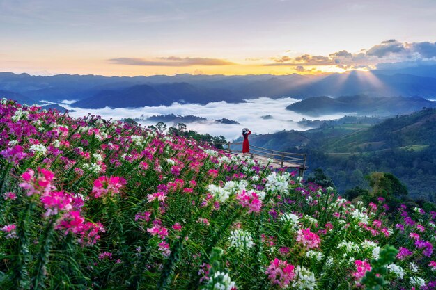 Full length of woman with pink flowering plants on field against sky