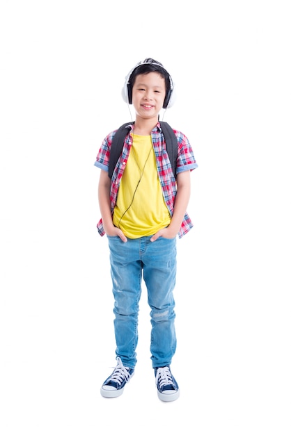 Full length of young asian boy standing and smiles over white background