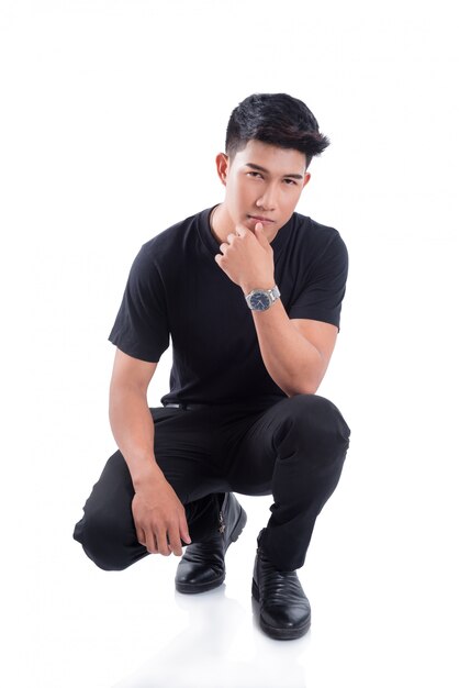 Full length of young asian handsome man sitting over white background