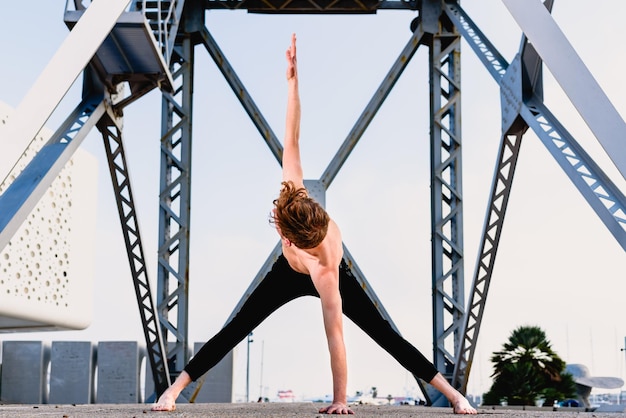 full length of young man exercising by metallic structure