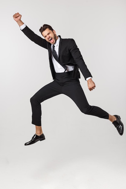 Full length of young man jumping over white background