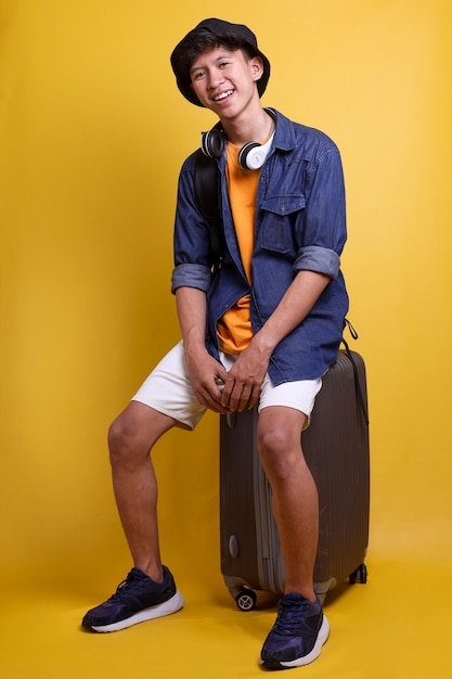 Full length of young traveler man wear bucket hat blue denim long sleeved shirt orange undershirt