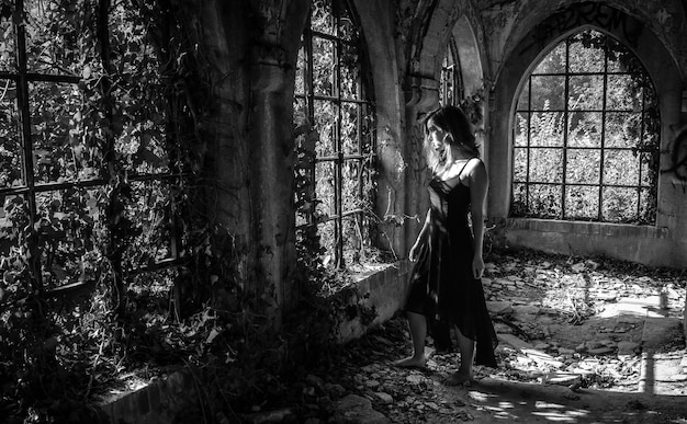 Photo full length of young woman standing on abandoned floor