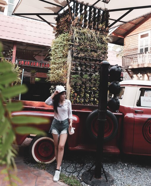 Photo full length of young woman standing against car