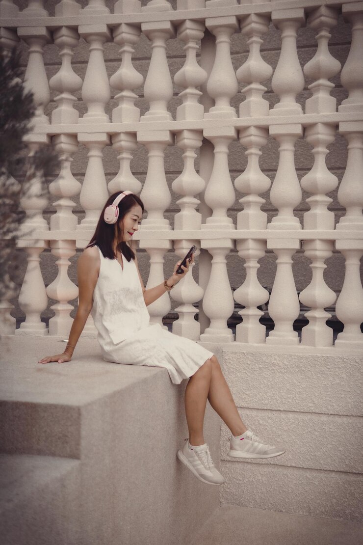 Photo 站在牆上的一位年輕女子的全長
