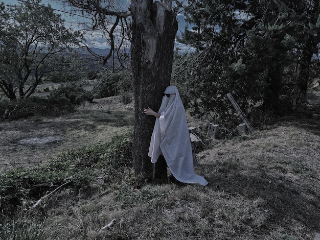 Full length of young woman standing by tree