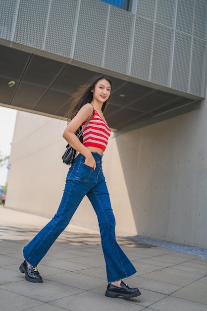 도시에서 서 있는 젊은 여성의 전체 길이