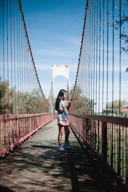 Photo full length of young woman standing on footbridge